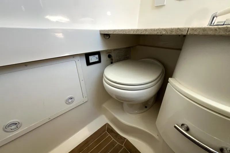 Slide: The Image of 2018 Regulator 34 Center Console boat bathroom with toilet and storage compartments. - 54