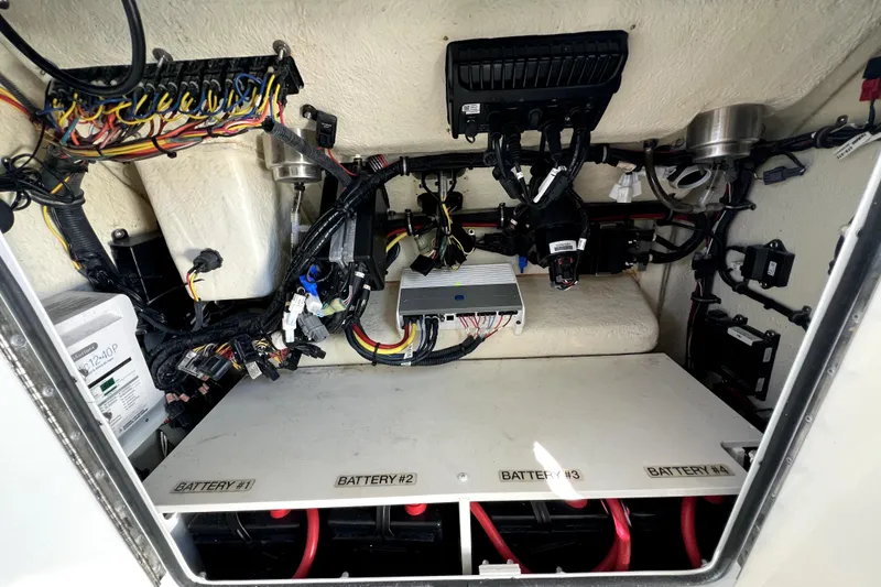 Slide: The Image of 2018 Regulator 34 Center Console electrical compartment with wiring and battery setup. - 56
