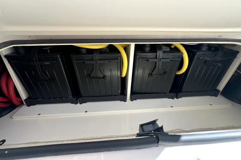 Slide: The Image of Battery compartment of a 2018 Regulator 34 Center Console boat with four black batteries. - 57