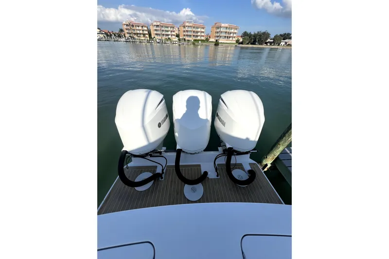 Slide: The Image of 2018 Regulator 34 Center Console boat with spacious seating, docked near lush greenery. - 9