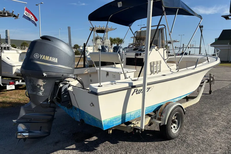 Slide: The Image of 1992 Parker 18 boat with Yamaha outboard motor on trailer, parked outdoors. - 4