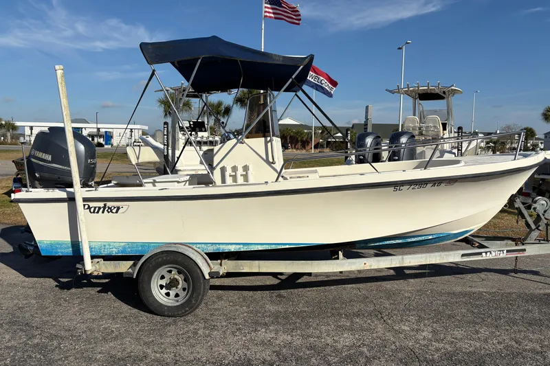 Slide: The Image of 1992 Parker 18 boat on trailer with Yamaha outboard motor, parked outdoors. - 5