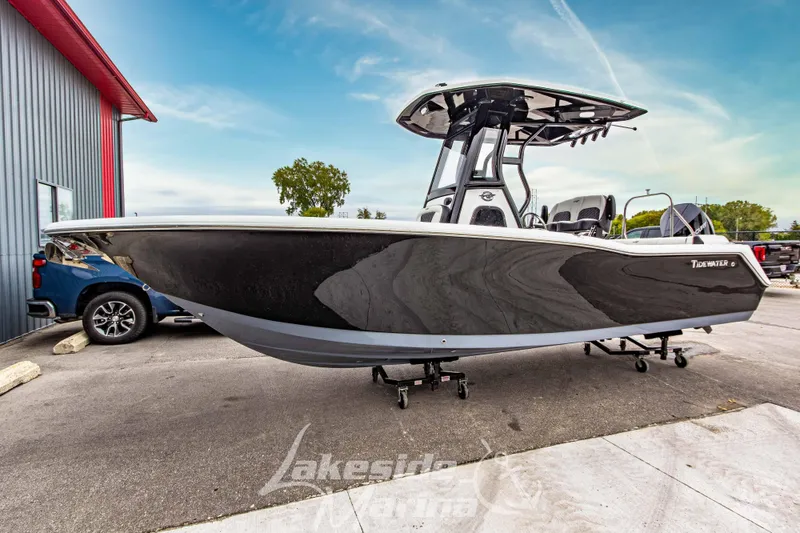 The Image of 2026 Tidewater 232 LXF boat cruising on a scenic lake with luxury homes in the background. - 0