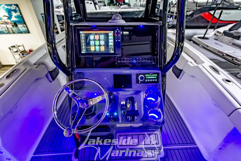 Slide: The Image of 2026 Tidewater 232 LXF boat interior with modern dashboard and seating, showcased indoors. - 26