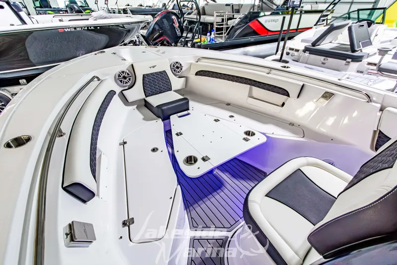 Slide: The Image of 2026 Tidewater 232 LXF boat interior with seating and table in showroom. - 44