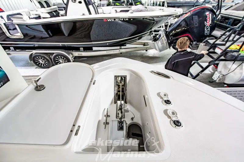 Slide: The Image of 2026 Tidewater 232 LXF boat displayed in showroom with other marine vessels. - 50