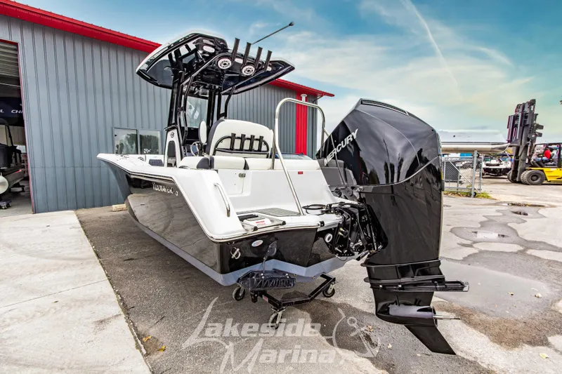 Slide: The Image of 2026 Tidewater 232 LXF boat with Mercury engine, parked outdoors near a building. - 53