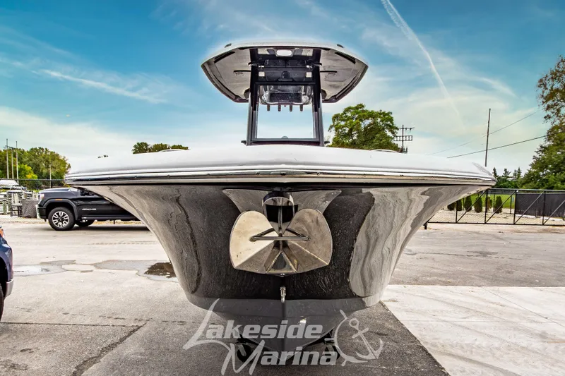 Slide: The Image of 2026 Tidewater 232 LXF boat at Lakeside Marina, sleek black design under clear sky. - 59