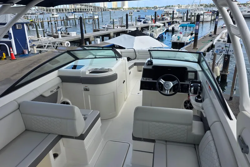 Slide: The Image of 2021 Sea Ray SDX 290 Outboard boat interior at marina, showcasing helm and seating area. - 14