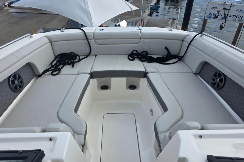Slide: The Image of 2021 Sea Ray SDX 290 Outboard boat interior with white seating and speakers. - 21