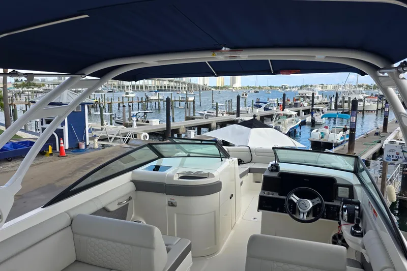 Slide: The Image of 2021 Sea Ray SDX 290 Outboard boat interior at marina, showcasing helm and seating area. - 25