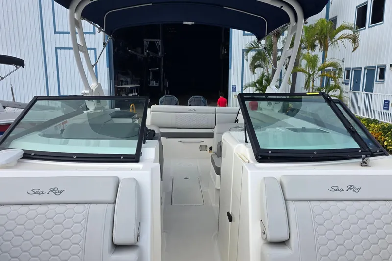 Slide: The Image of 2021 Sea Ray SDX 290 Outboard boat with open cockpit and seating, docked near palm trees. - 27