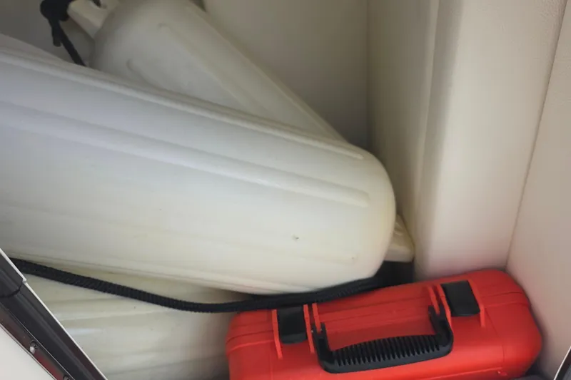 Slide: The Image of Storage compartment of 2021 Sea Ray SDX 290 Outboard with fenders and red toolbox. - 36