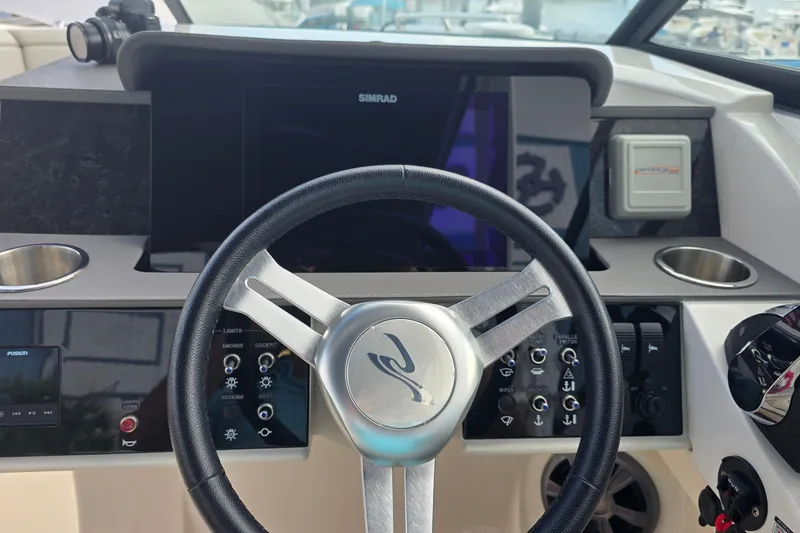 Slide: The Image of 2021 Sea Ray SDX 290 Outboard helm with steering wheel and control panel. - 9