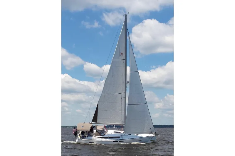 The Image of 2013 Jeanneau Sun Odyssey 409 sailing on open water under a clear blue sky. - 0