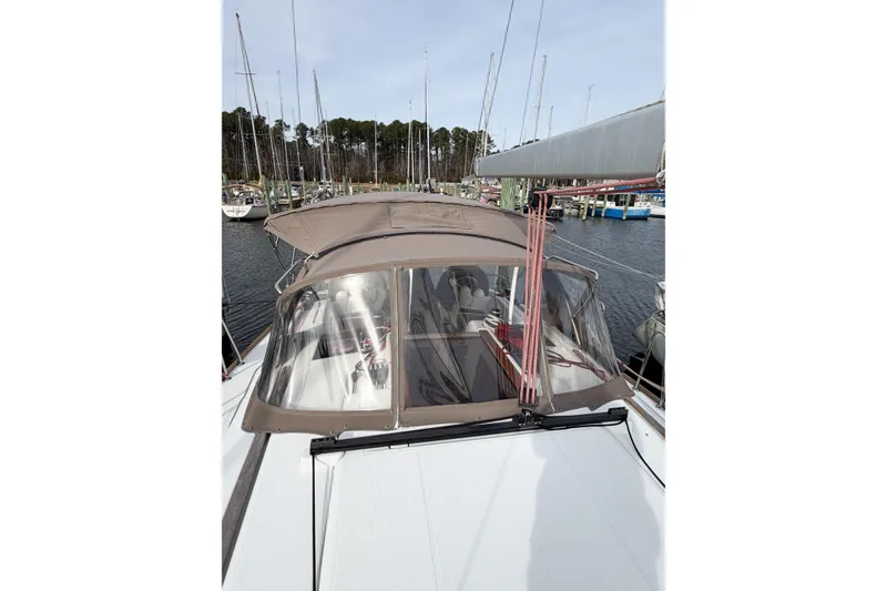 Slide: The Image of 2013 Jeanneau Sun Odyssey 409 sailboat docked at marina, featuring a covered cockpit. - 13