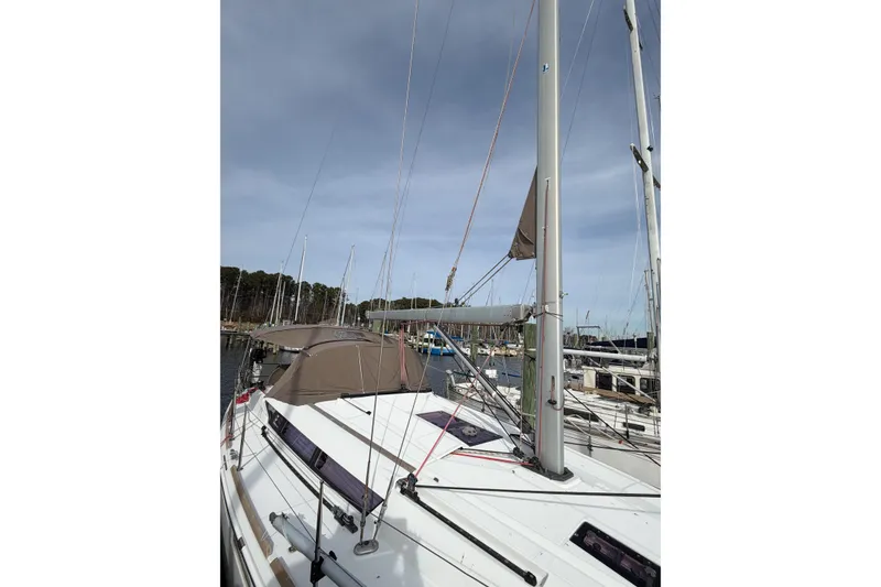 Slide: The Image of 2013 Jeanneau Sun Odyssey 409 sailboat docked at marina, clear sky background. - 2