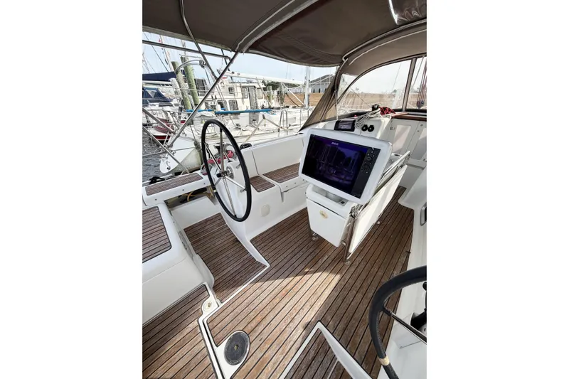 Slide: The Image of Cockpit of 2013 Jeanneau Sun Odyssey 409 sailboat with wooden flooring and navigation equipment. - 24