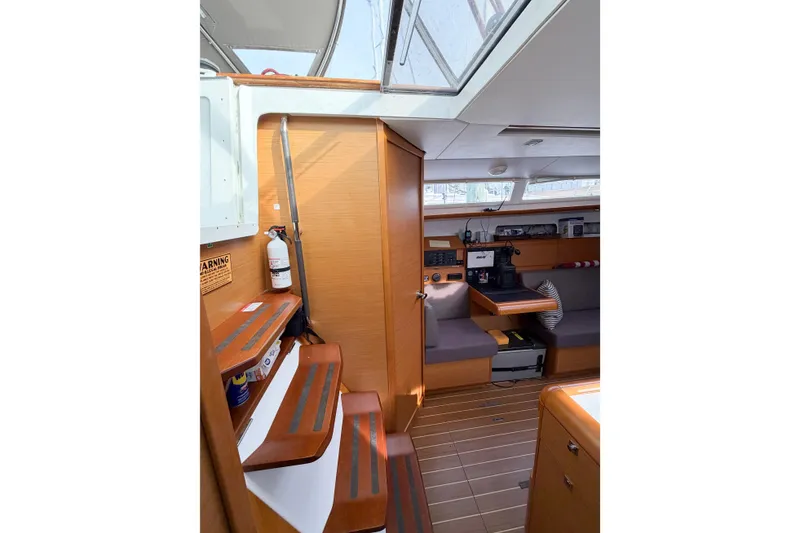 Slide: The Image of Interior of 2013 Jeanneau Sun Odyssey 409 sailboat, featuring wooden cabinetry and seating area. - 40
