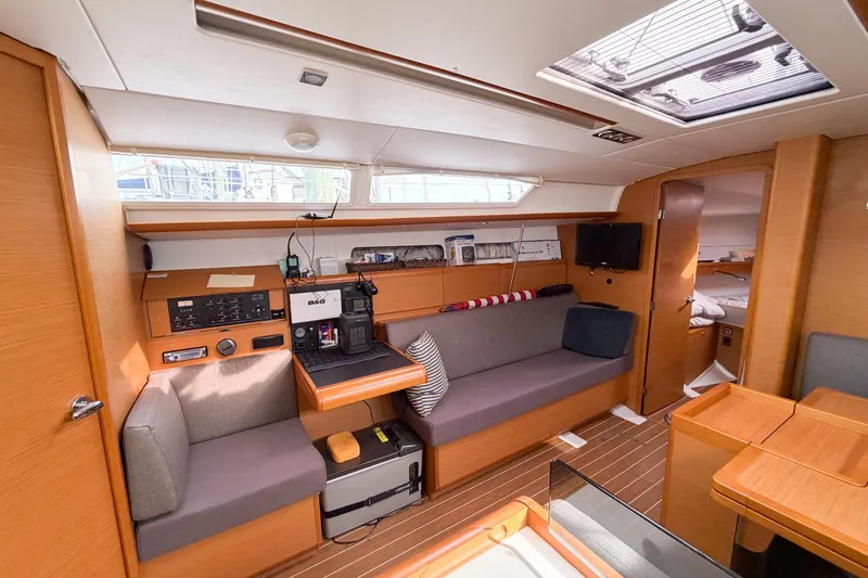 Slide: The Image of Interior of 2013 Jeanneau Sun Odyssey 409 sailboat, featuring cozy seating and navigation equipment. - 44