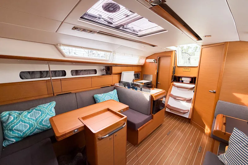 Slide: The Image of Interior of 2013 Jeanneau Sun Odyssey 409 yacht, featuring modern wood finish and cozy seating. - 45