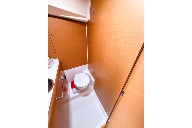Slide: The Image of 2013 Jeanneau Sun Odyssey 409 yacht bathroom with wooden paneling and compact toilet. - 51