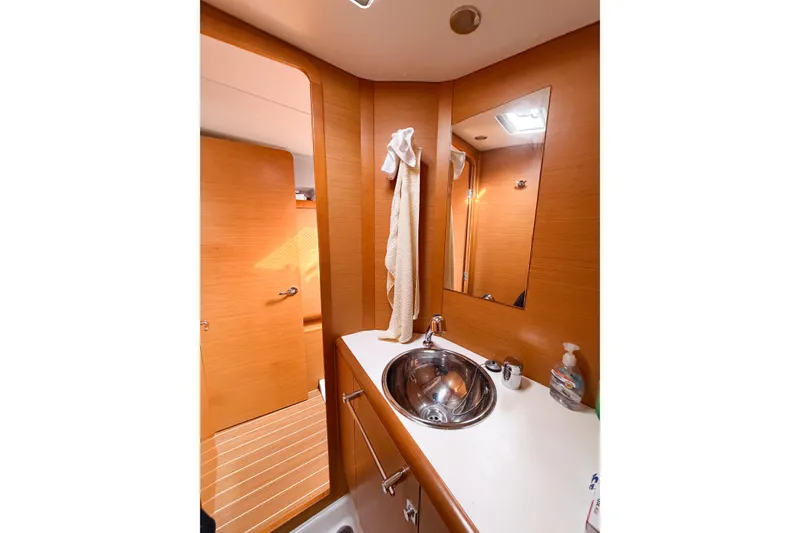 Slide: The Image of Bathroom interior of 2013 Jeanneau Sun Odyssey 409 yacht with wooden finish and stainless steel sink. - 52