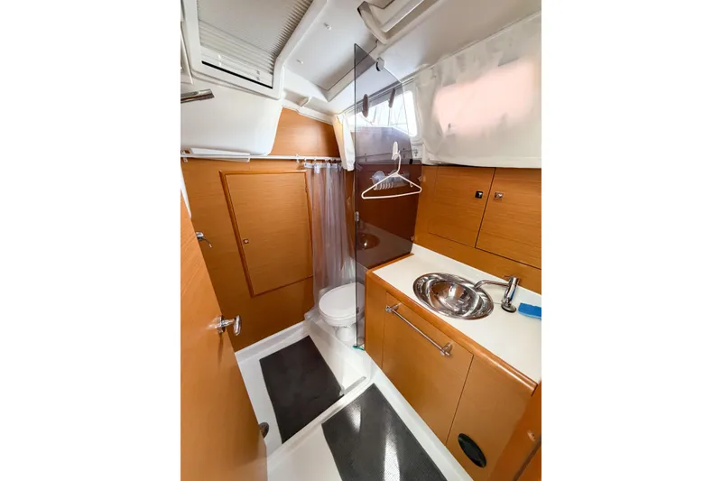 Slide: The Image of Bathroom interior of 2013 Jeanneau Sun Odyssey 409 yacht, featuring wooden cabinetry and modern fixtures. - 61