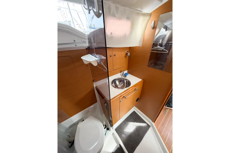 Slide: The Image of 2013 Jeanneau Sun Odyssey 409 bathroom with modern fixtures and wooden cabinetry. - 64