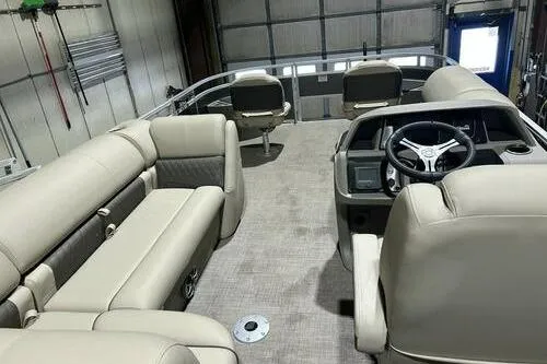 Slide: The Image of 2024 Sun Tracker Fishin' Barge 20 DLX interior with beige seating and steering console. - 11