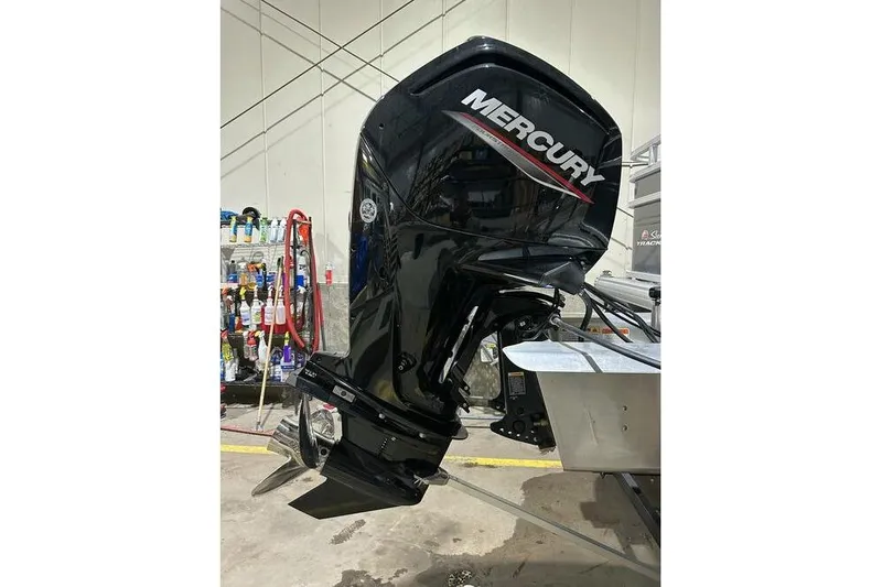 Slide: The Image of 2024 Sun Tracker Fishin' Barge 20 DLX with Mercury outboard motor in a showroom. - 14