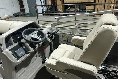 Slide: The Image of 2024 Sun Tracker Fishin' Barge 20 DLX interior with steering wheel and beige seating. - 8