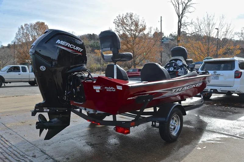 Slide: The Image of 2023 Tracker Pro Team 175 TXW boat with Mercury engine, parked outdoors. - 14