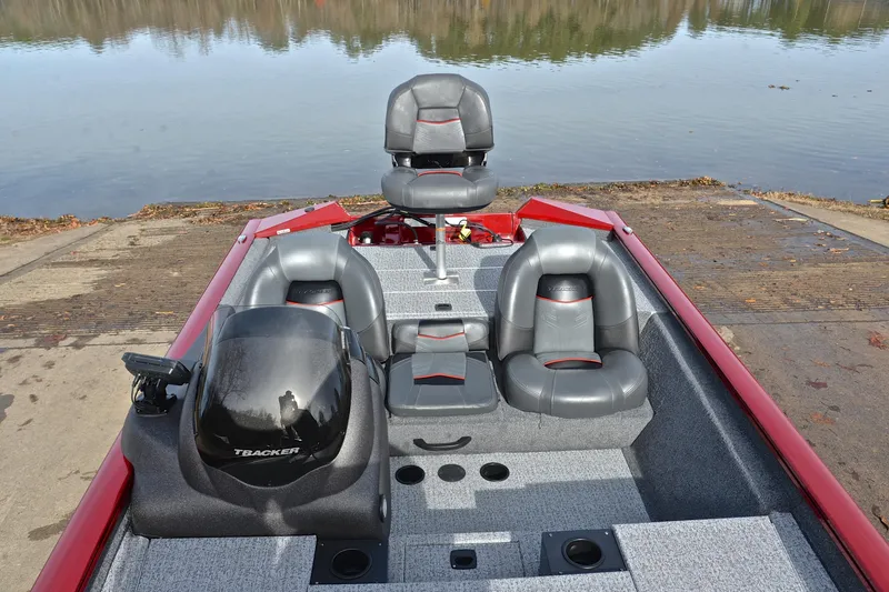 Slide: The Image of 2023 Tracker Pro Team 175 TXW boat interior with gray seats by the water. - 23