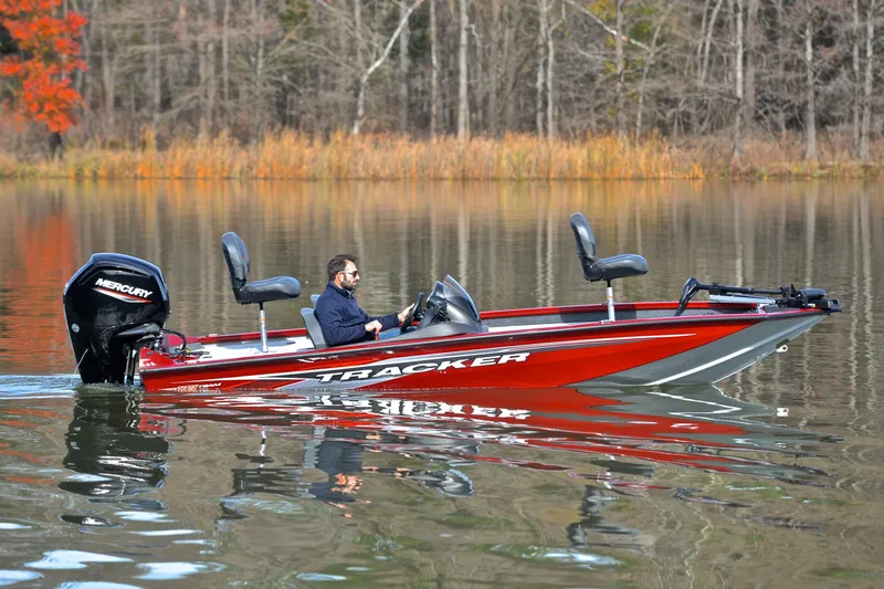 Slide: The Image of 2023 Tracker Pro Team 175 TXW boat on a calm lake with autumn trees. - 7
