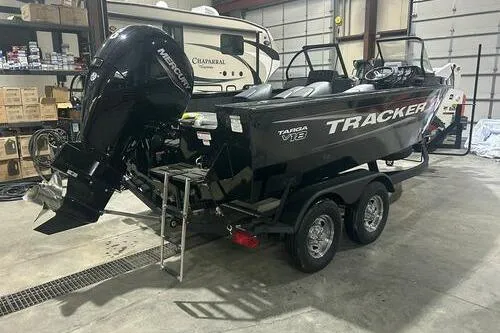 Slide: The Image of 2026 Tracker Targa V-18 Combo boat in garage, featuring dual-axle trailer and Mercury outboard motor. - 4