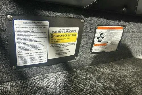 Slide: The Image of 2026 Tracker Targa V-18 Combo boat capacity and safety labels on interior surface. - 8