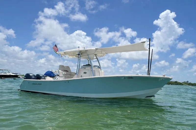 Slide: The Image of 2012 Regulator 24 Forward Seating boat on water under blue sky. - 1