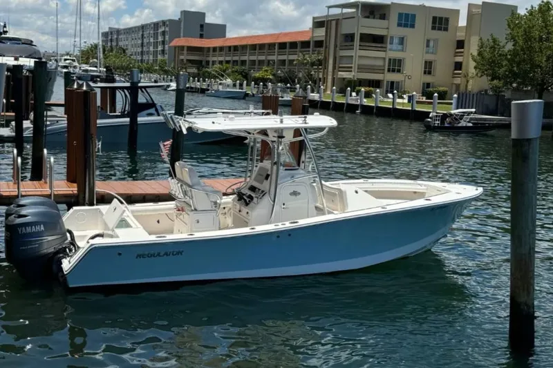 Slide: The Image of 2012 Regulator 24 Forward Seating boat docked in a marina with Yamaha engine. - 2