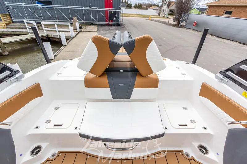 Slide: The Image of 2025 Chaparral 21 SSi boat interior with tan and white seating at dockside. - 15