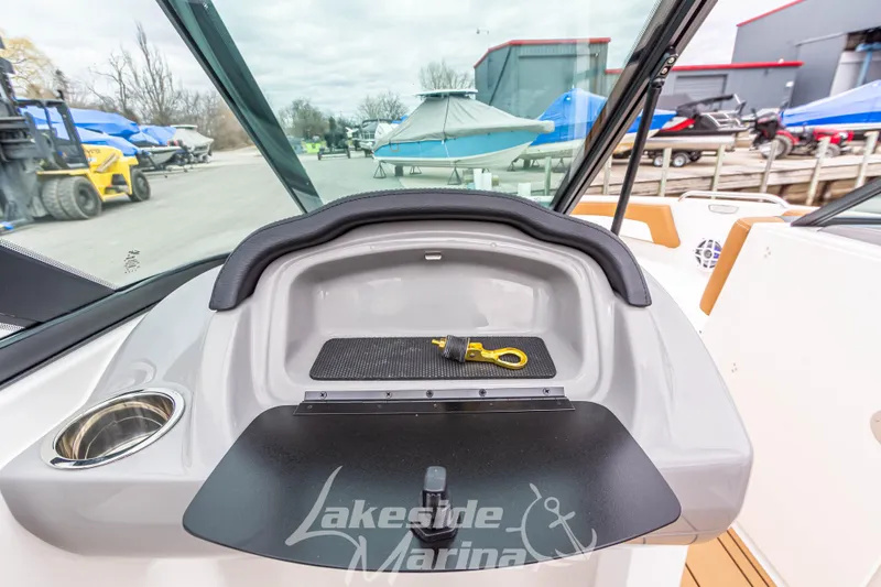 Slide: The Image of 2025 Chaparral 21 SSi boat dashboard with storage compartment and cup holder at Lakeside Marina. - 25