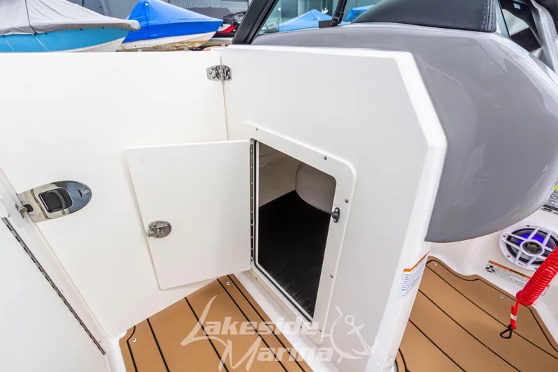 Slide: The Image of 2025 Chaparral 21 SSi boat storage compartment with open door, showcasing interior space. - 27