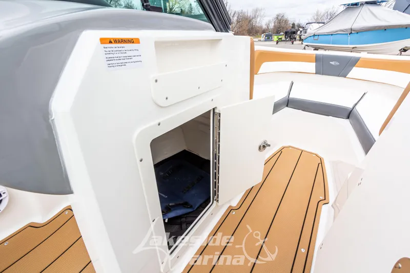 Slide: The Image of 2025 Chaparral 21 SSi boat interior with open storage compartment and teak flooring. - 28