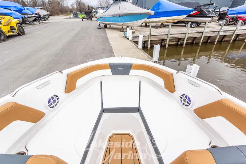Slide: The Image of 2025 Chaparral 21 SSi boat interior with tan and white seating at marina. - 29
