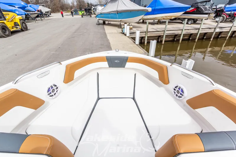 Slide: The Image of 2025 Chaparral 21 SSi boat interior with tan and white seating at marina dock. - 31