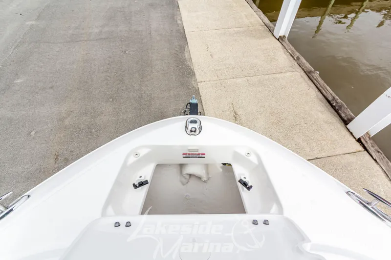 Slide: The Image of 2025 Chaparral 21 SSi boat bow view at dockside, featuring storage compartment. - 32