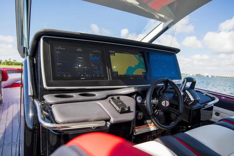 Slide: The Image of 2025 Cigarette 41 Nighthawk boat dashboard with advanced navigation screens and controls. - 26