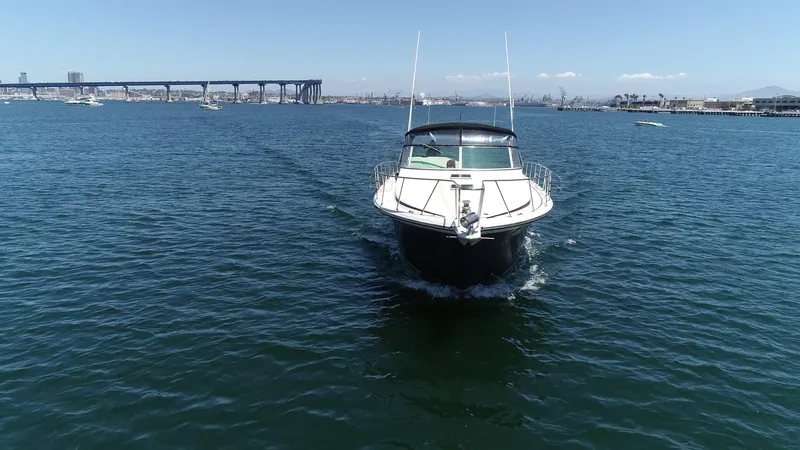 Slide: The Image of 1988 Californian Veneti boat cruising on open water with cityscape and bridge in background. - 10