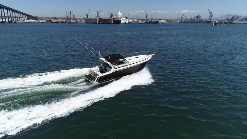 Slide: The Image of 1988 Californian Veneti boat cruising in a harbor with industrial cranes in the background. - 13
