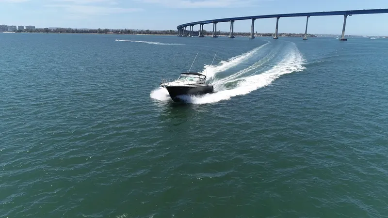 Slide: The Image of A 1988 Californian Veneti boat cruising on open water near a long bridge. - 16